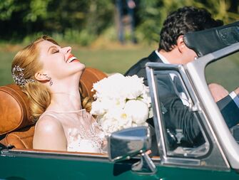 Bride and groom driving away from wedding