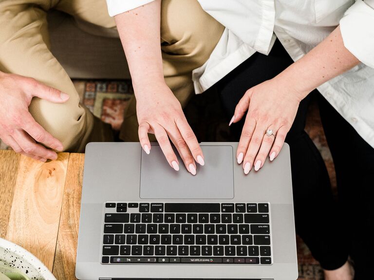 Couple creating all-in-one wedding registry on laptop 2023 trend