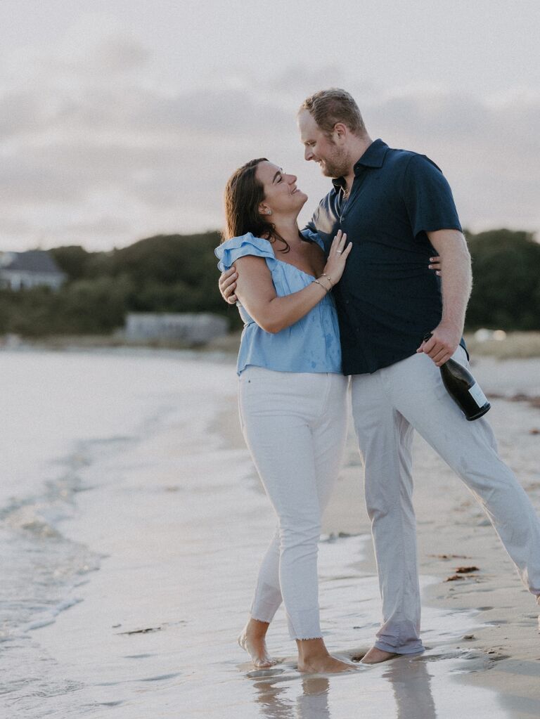 Couple poses on the beach for their summer engagement photo session. 