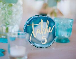 unique wedding table number idea with gold calligraphy written onto blue geode stone