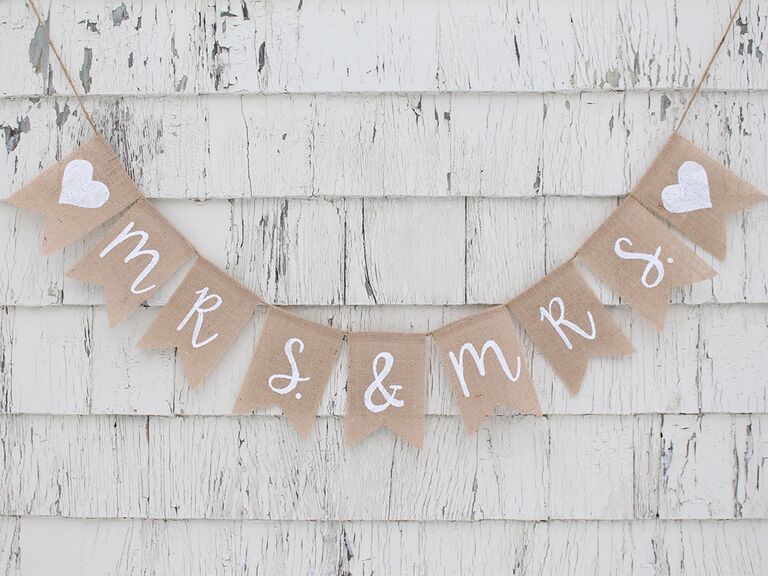 Mrs. & Mrs. on burlap pennants in simple white script with hearts at beginning and end