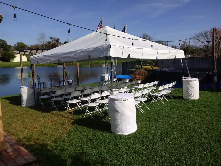 White outdoor wedding tent rental by pond from Carter's Family Rent All in Daytona Beach, Florida