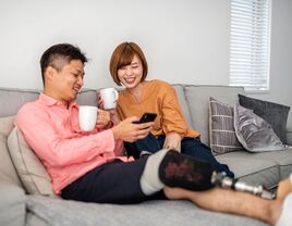 Disabled man sitting on couch with partner planning wedding