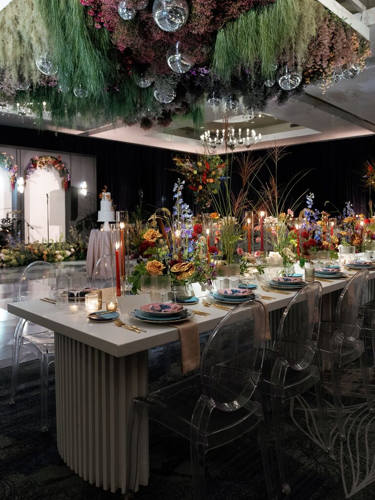 Colorful wedding reception space with suspended flowers and disco balls