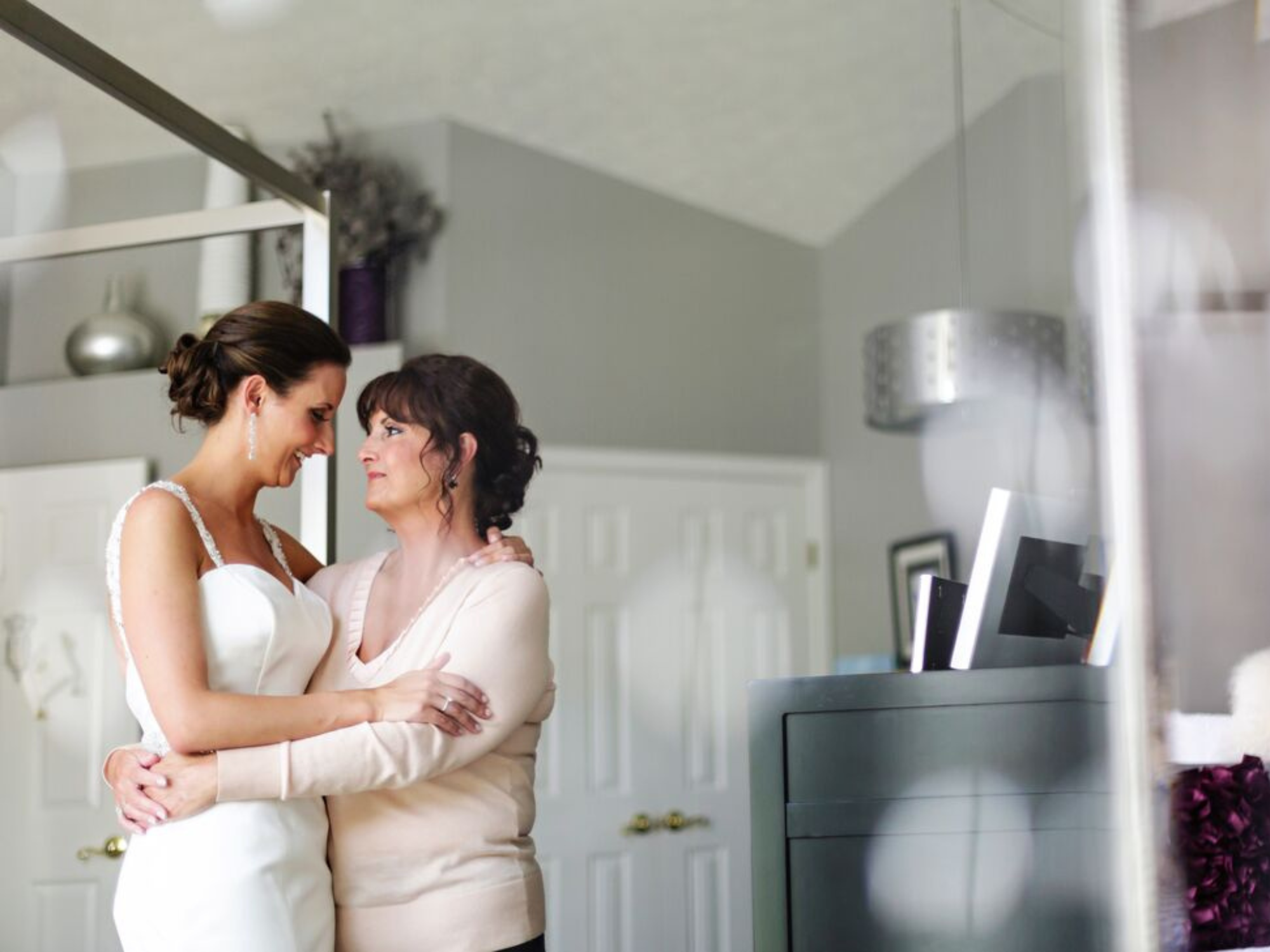 Bride and her mother hugging each other on wedding day
