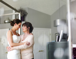 Bride and her mother hugging each other on wedding day