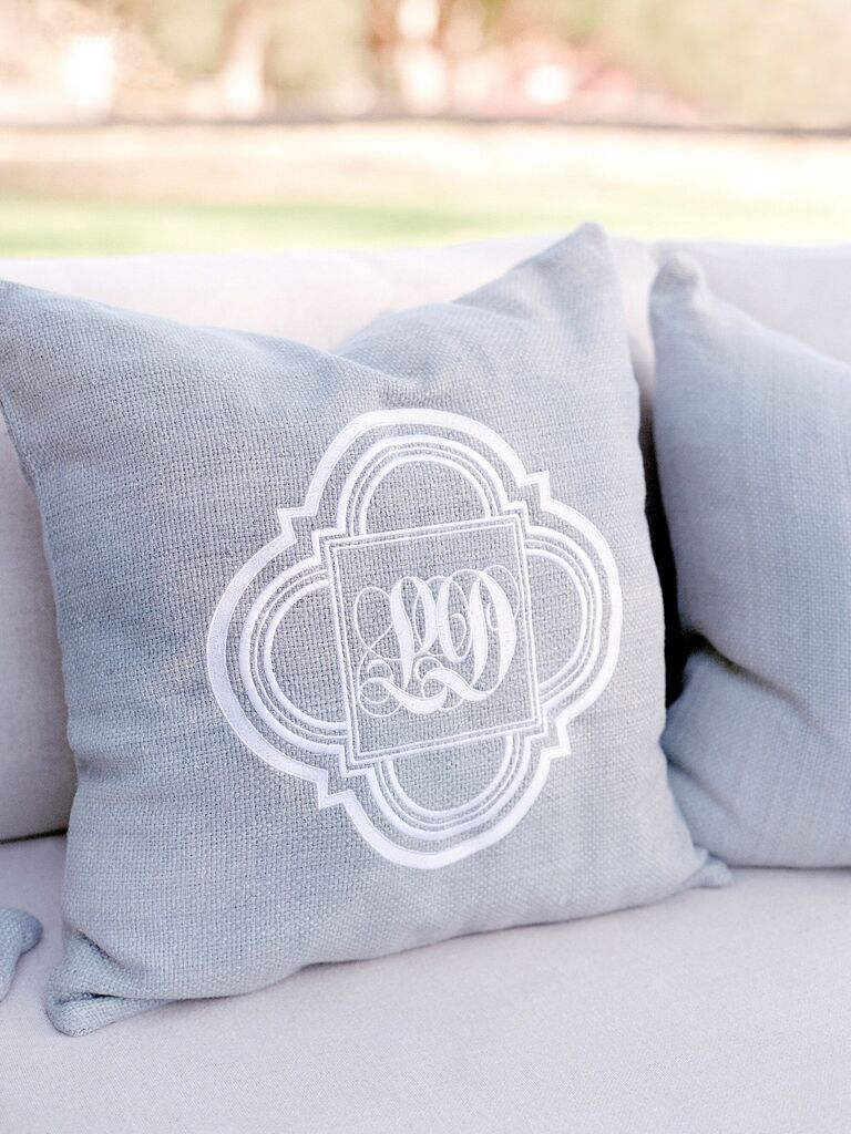 gray throw pillow at wedding lounge area decorated with white embroidered monogram