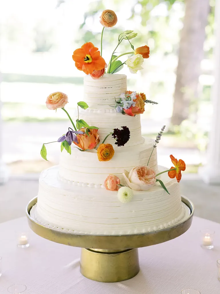 Four tier white wedding cake with floral accents, taylor swift themed wedding
